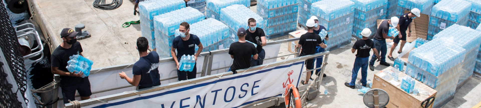 Chargement de pack d'eau Saint Vincent dans un bateau